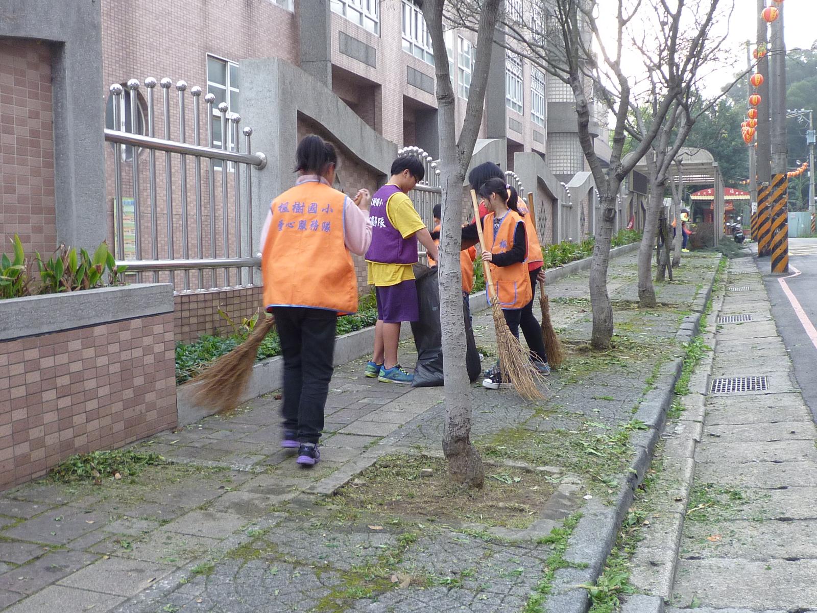 高年級孩子負責打掃校園圍牆周圍，開新視窗